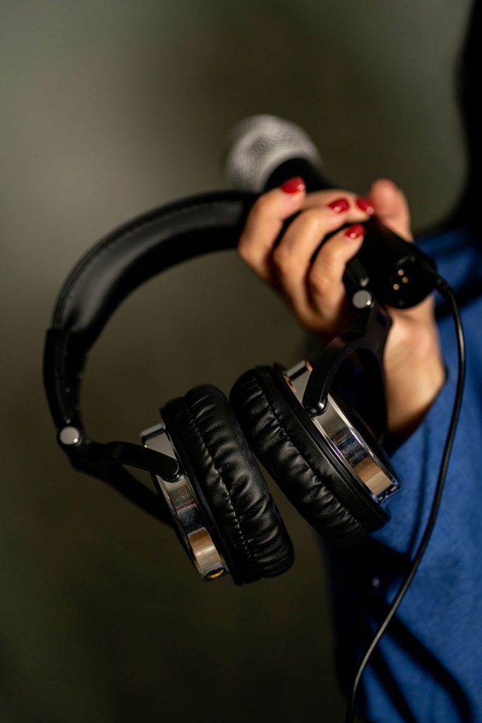 Person holding a microphone and headphones